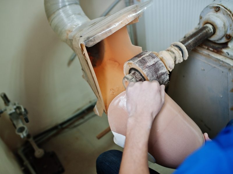 Prosthetist man making prosthetic leg while working in laboratory.